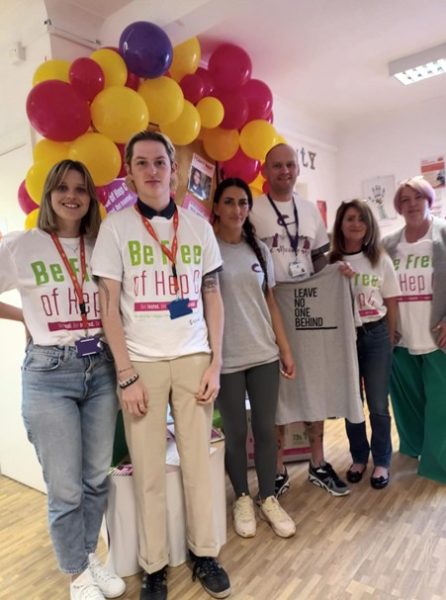 group photo of staff in be free of hep c tshirts smiling at the camera